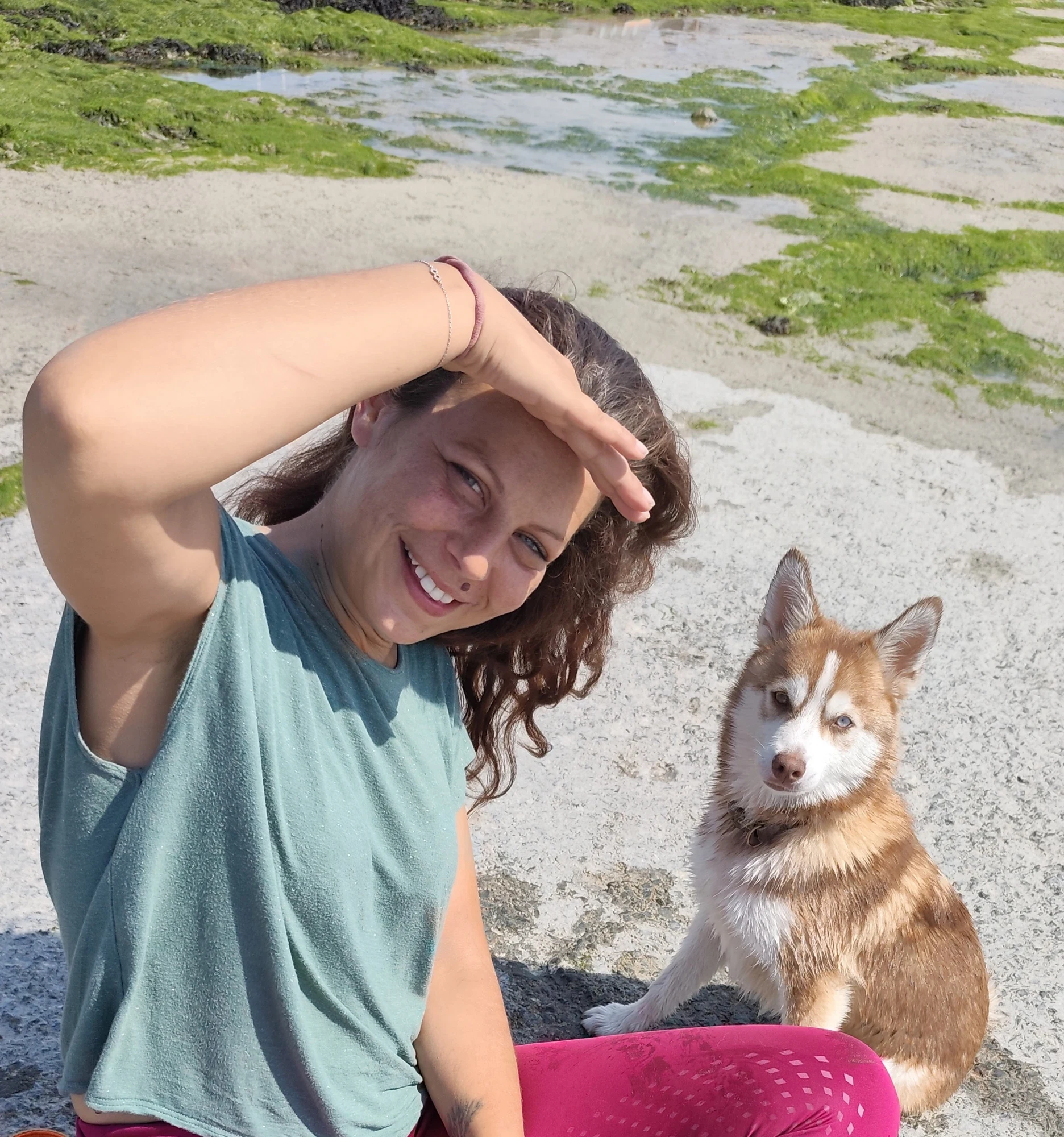 Enfant souriante et Bueno complices au bord de la mer